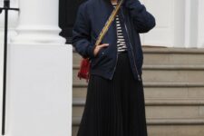 05 a navy and white t-shirt, a black pleated midi skirt, a navy bomber jacket, red trainers and a red crossbody bag