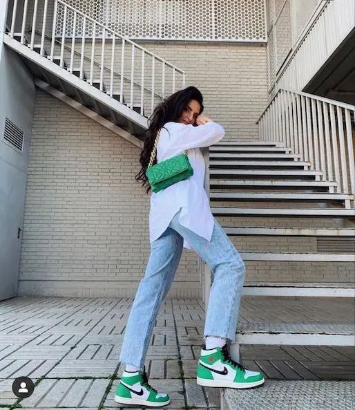 a white oversized shirt, bleached blue jeans, green Jordan sneakers, a green bag with chain are a cool look