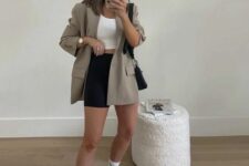 07 a white crop top, a black mini skirt, an oversized grey blazer, white New Balance trainers and white socks, black bags