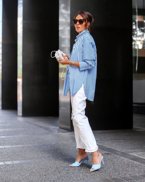 a blue stripe shirt, white ripped jeans, blue heels, a small white bag for a simple and cool vacation look