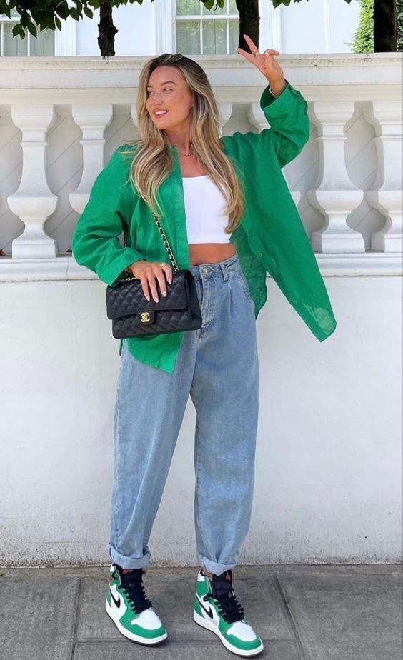 a white crop top, bleached baggy jeans, green Jordans, a matching green button down and a black bag with chain