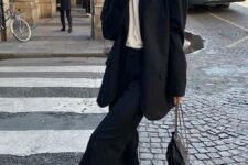 13 a black pantsuit with an oversized blazer, a white t-shirt, a chain necklace, white trainers and a black bag
