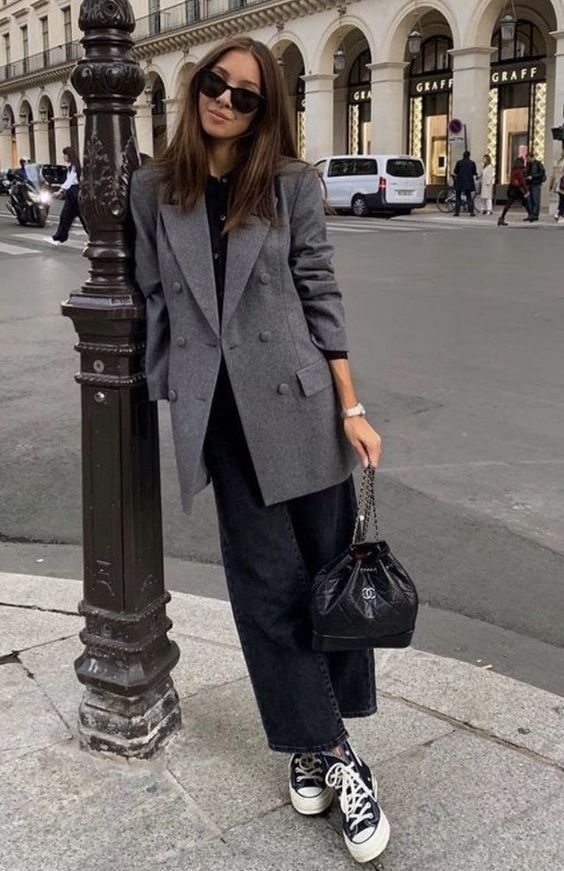 a simple monochromatic work outfit with a black tee, black jeans, black sneakers, a black bag and a grey oversized blazer