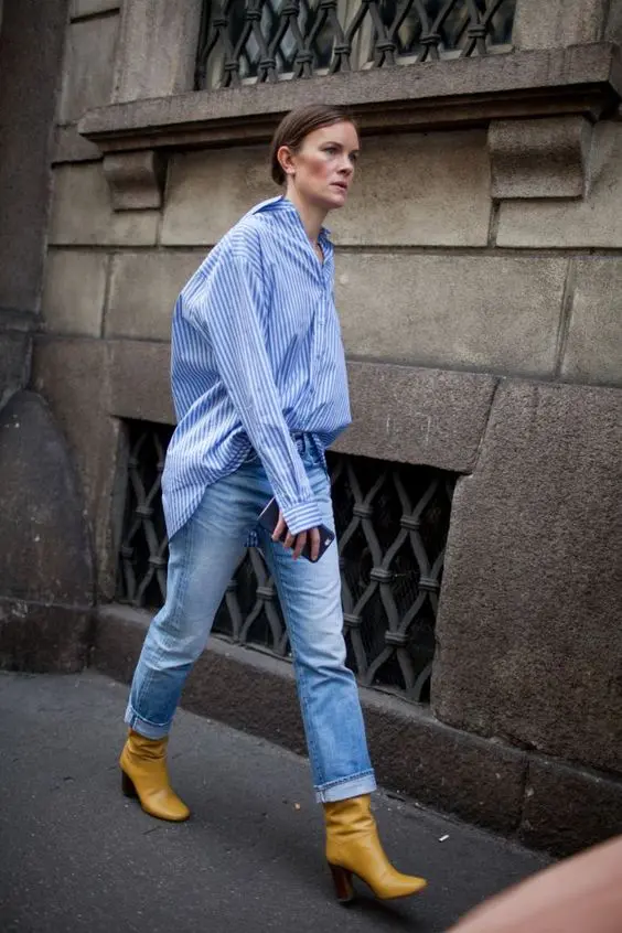 an oversized blue striped shirt, blue bleached jeans, mustard-colored boots for a stylish fall look