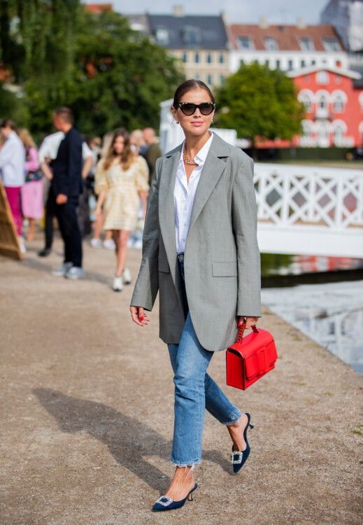 a white button down, blue jeans, an oversized grey blazer, navy embellished kitten heels and a bold red bag for work