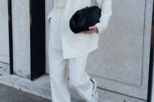 20 a creamy pantsuit, a neutral top, grey New Balance trainers and a black clutch
