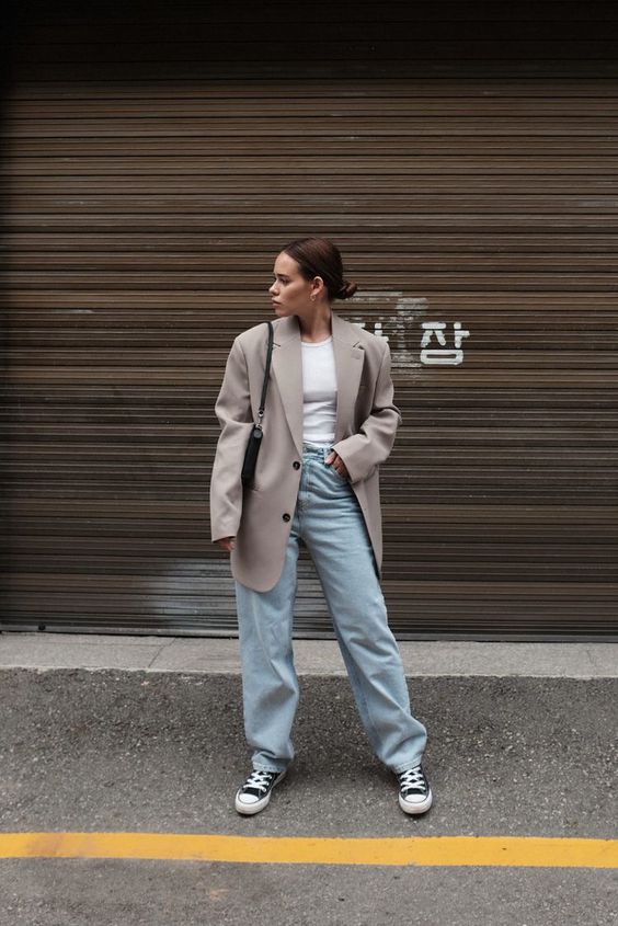 a white t-shirt, bleached blue jeans, black sneakers, an oversized grey blazer and a black bag are a nice and comfy look for spring