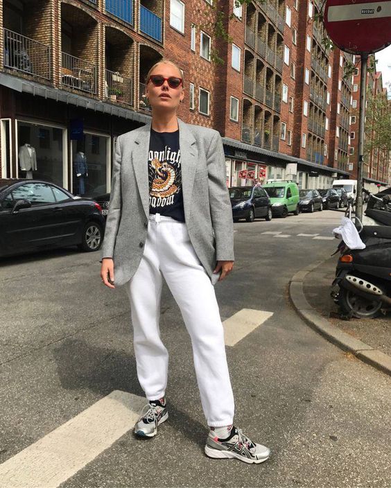 a black printed t-shirt, white sweatpants, grey trainers and a grey blazer are a comfy everyday look for spring