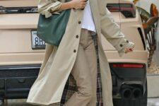 29 a simple spring look with a white t-shirt, beige trousers, a tan trench, white New Balance trainers, a green hobo bag