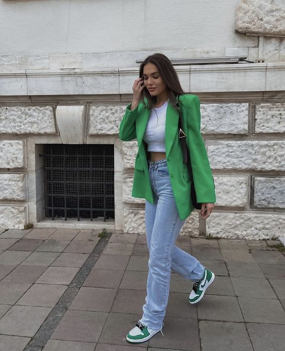 a white crop top, bleached blue jeans, grene Jordan sneakers, a green oversized blazer and a black bag for spring