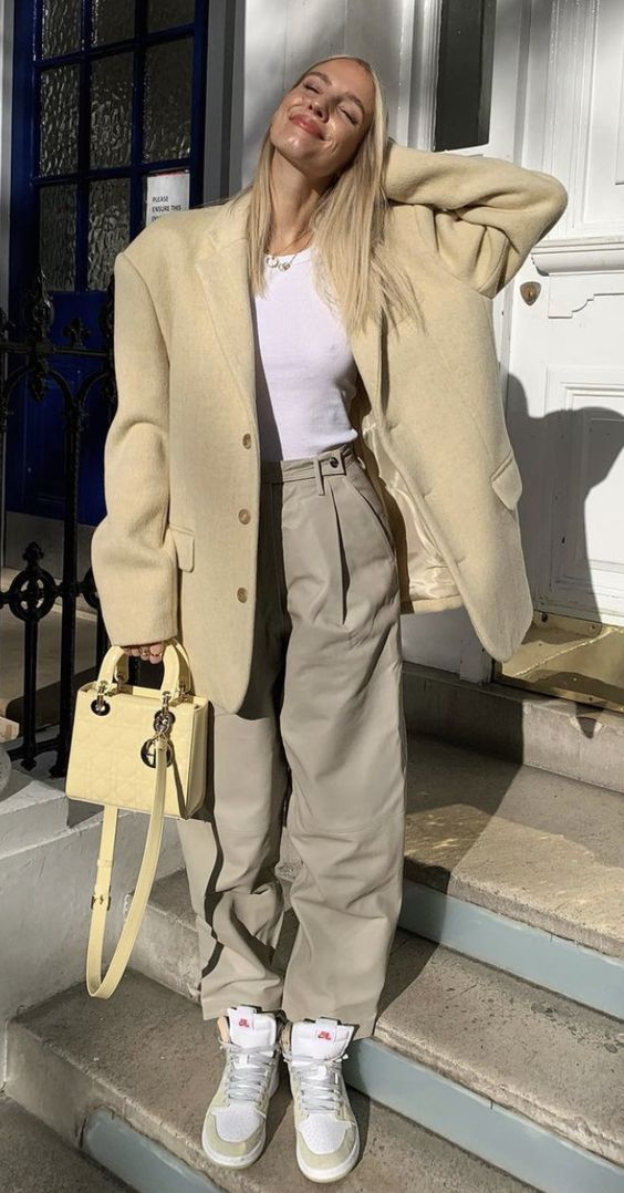 a white tank top, grey trousers, a pastel yellow oversized blazer, white and yellow Jordan sneakers and a yellow bag for spring