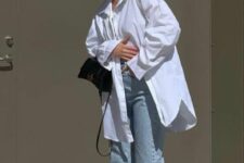 43 bleached jeans, an oversized white shirt, white New Balance trainers, a black mini bag for a relaxed and comfy spring look