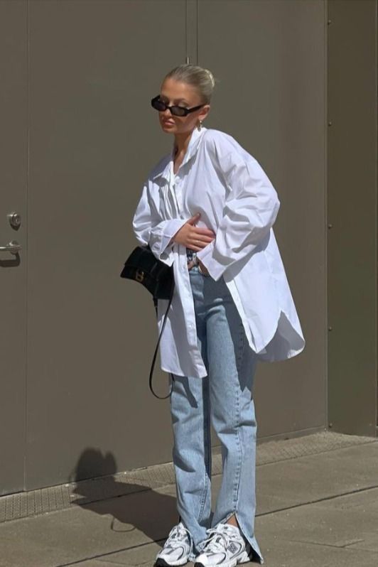 bleached jeans, an oversized white shirt, white New Balance trainers, a black mini bag for a relaxed and comfy spring look