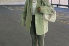 45 dark green leggings, a light green oversized blazer and a pale green bag, a white top, white trainers and socks and a white cap