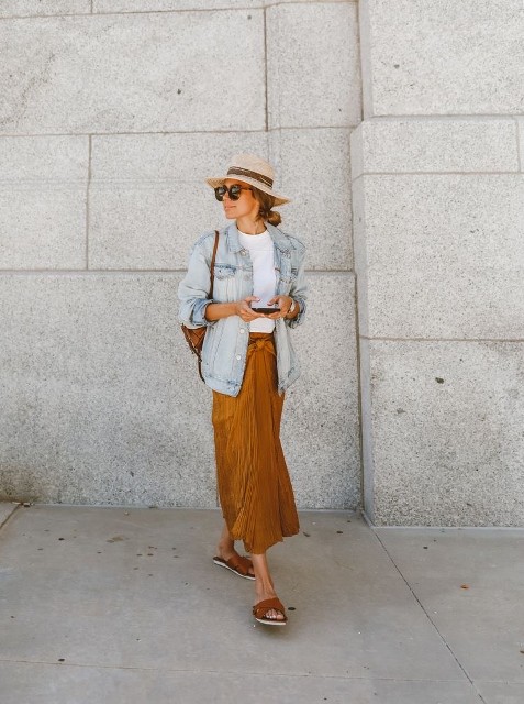 With beige and brown wide brim hat, sunglasses, brown bag, white t-shirt and brown leather flat mules