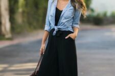 With black top, golden necklace, oversized rounded sunglasses, black leather tote bag and black leather high heeled mules