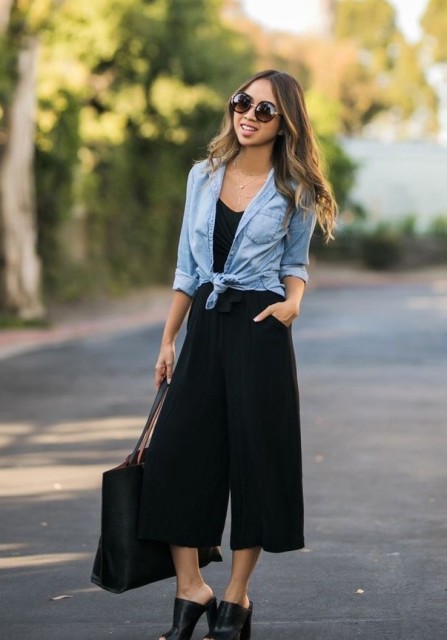 With black top, golden necklace, oversized rounded sunglasses, black leather tote bag and black leather high heeled mules
