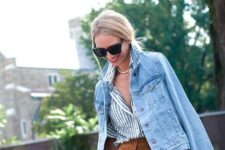 With oversized sunglasses, white and blue striped button down shirt, golden necklace and black leather clutch