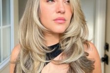 a beautiful bronde to blonde long butterfly haircut with wavy ends and a bit of volume is a stylish idea to rock