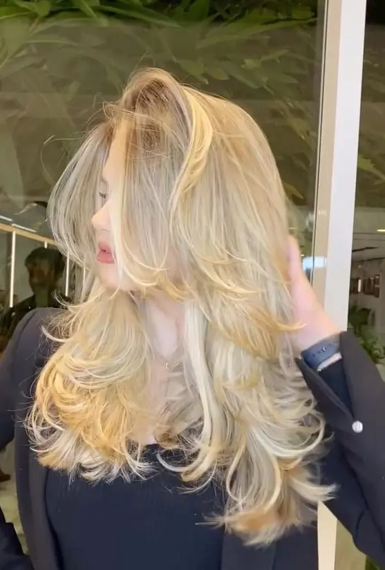 a beautiful creamy blonde butterfly haircut with wavy ends and a lot of volume is a lovely idea to try on your blonde locks