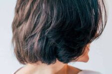 a black choppy bob with center parted bangs that help to freshen things up