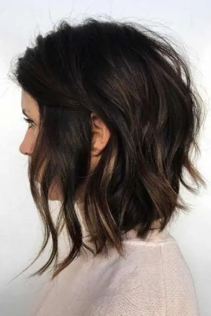a black choppy bob with lowlights and waves looks beautiful and is low maintenance