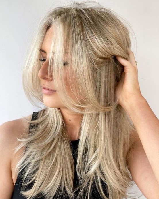 a bleached blonde butterfly haircut with curled ends and a bit of volume is a stylish idea for anyone