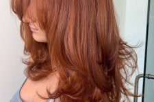 a breathtaking long red butterfly haircut with a lot of volume, wispy bangs and curled ends is a lovely idea