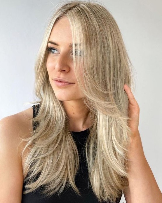 a bright blonde butterfly haircut with curved ends is a lovely idea for a chic and beach-inspired look