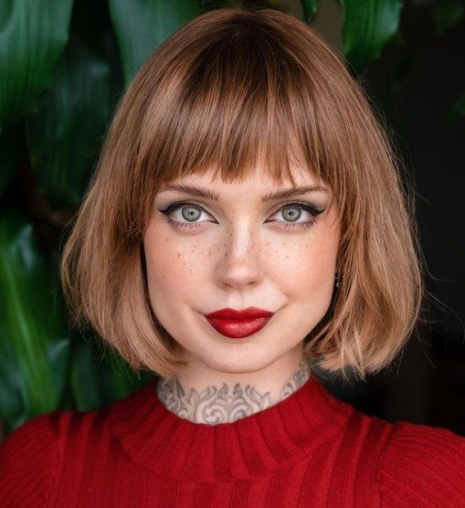 a brown reddish chin length bob with blunt textured bangs and curved ends is a lovely idea