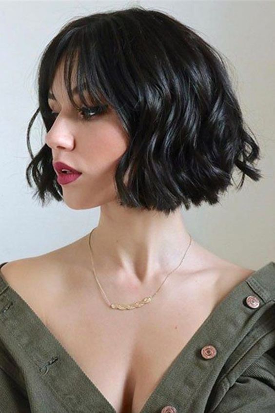a catchy black wavy chin length bob with wispy bangs is a gorgeous idea that looks very feminine