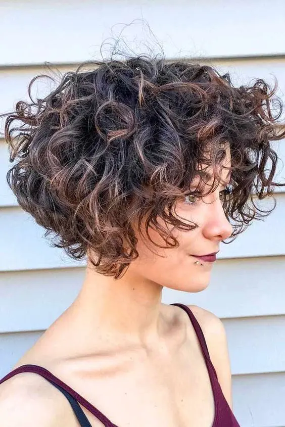 a chin length bob on naturally curly hair with caramel highlights is a stylish and catchy idea and it looks cool