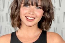 a choppy and shiny brown bob with waves and wispy bangs is a stylish idea that always works