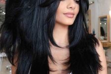a fabulous long black butterfly haircut with curtain bangs and curled ends is a chic and very catchy idea