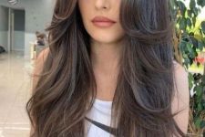 a long brunette butterfly haircut with curled ends and a lot of volume is amazing to torck