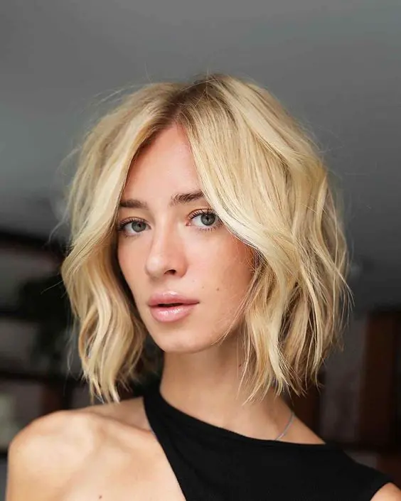 a lovely and pretty blonde choppy bob with central part and a darker root is a classy solution to rock