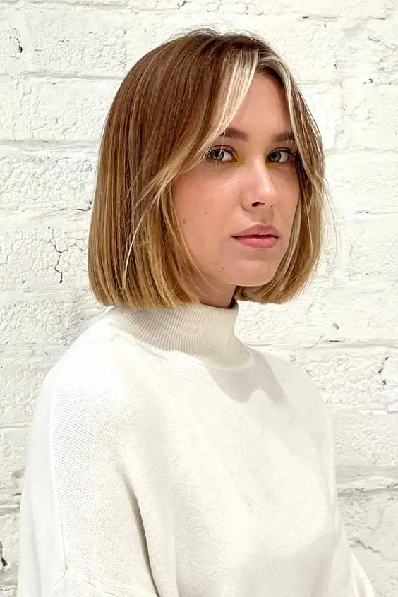 a pretty brown to blonde ombre bob with short curtain bangs that are done icy blonde is a cool and catchy idea