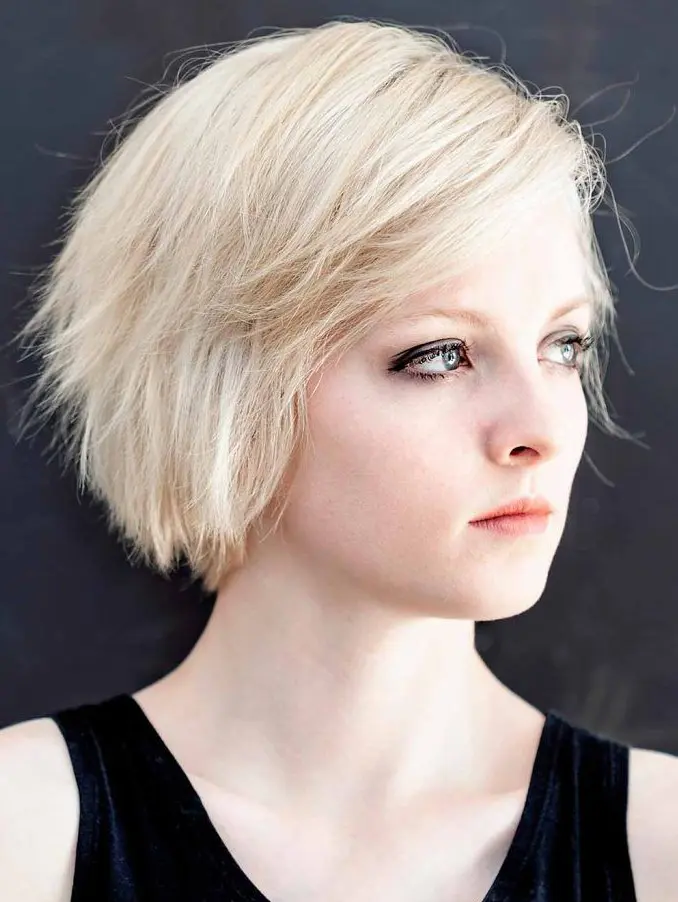 a side-parted choppy blond bob works great for women with round faces, giving a bit of an edge