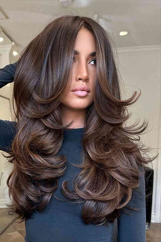 a stunning dark brunette butterfly haircut with a lot of volume and curled ends is amazing to rock