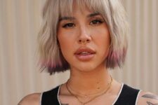 a super bold textural blonde chin length bob with bangs, pink and purple ends is a catchy idea for those who want a statement