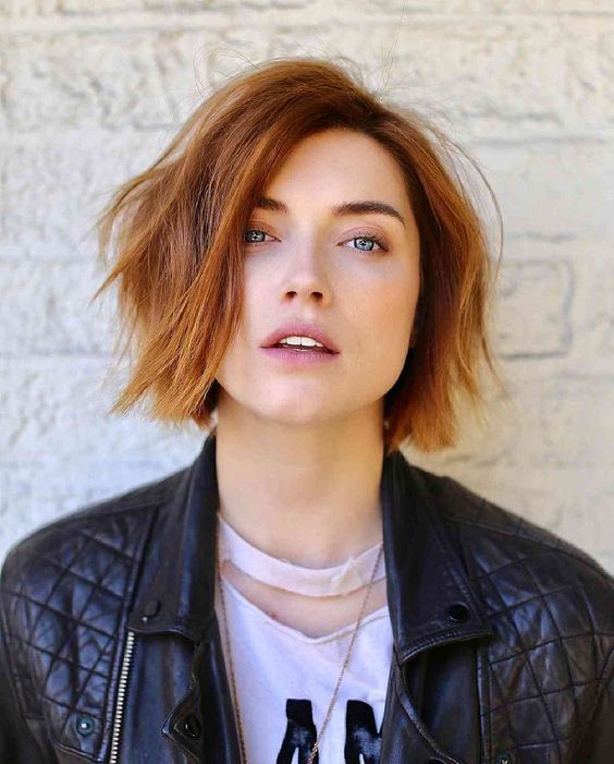 a textural and messy ginger chin length bob with a darker root and side parting is super bold