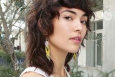 a wavy and shaggy long mullet with bangs and longer hair on the back is a creative and soft way to wear this cut