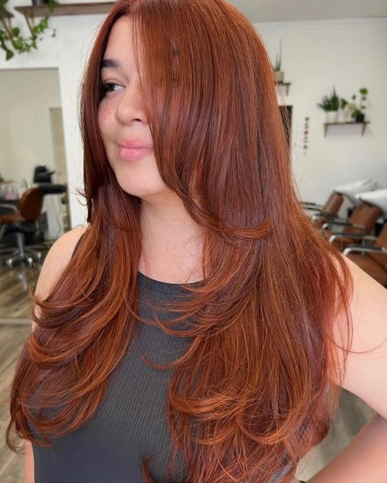 an inspiring and beautiful red butterfly haircut on long hair, with much volume and long curtain bangs is wow