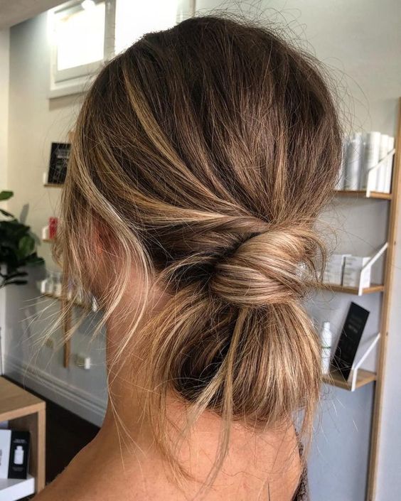 a messy and texured low bun with a twisted touch and a volume on top, some locks down is lovely