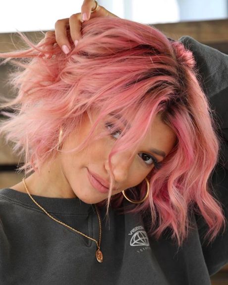 a hot pink wavy bob with a darker root and messy waves is a bold and catchy idea that will turn heads