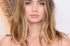 Ana de Armas wearing light brunette hair and sunkissed balayage looks gorgeous and messy texture adds a relaxed touch
