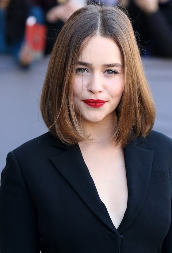 Emilia Clarke wearing a dark brunette collarbone bob with a touch of balayage and side parting is timeless classics