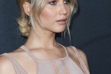 Jennifer Lawrence wearing a low blonde bun and side chin bangs plus middle part looks fabulous