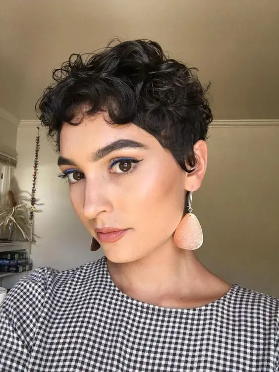a beautiful and super cute almost black wavy pixie with a bit of bangs and longer sides looks really chic and cool