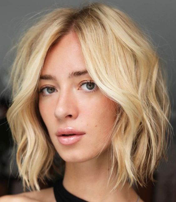 a beautiful textural blonde medium bob with side part and shaggy layers is a bold and catchy solution